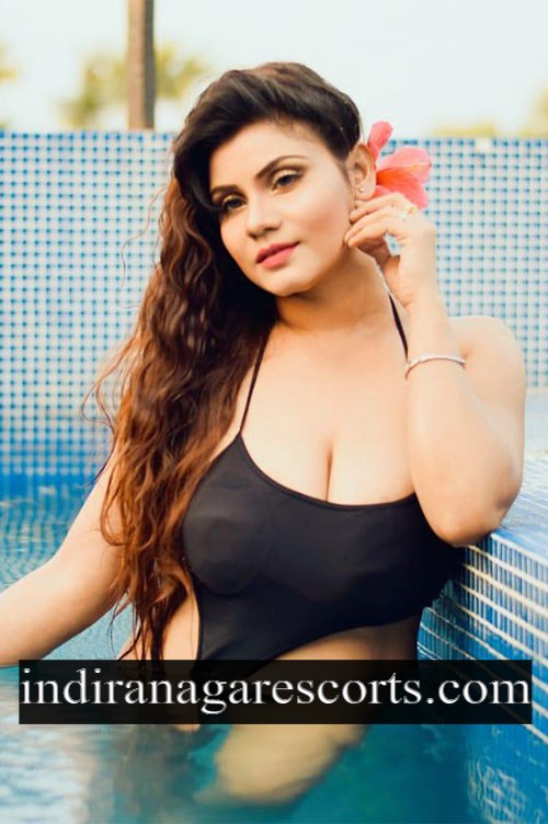 Jyothika, Indiranagar call girl, in the pool holding a pink flower to her ear