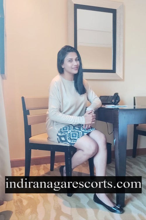 Jyothika, independent Indiranagar escort, sitting on a chair in a hotel room